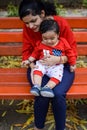 Loving mom carrying of her baby at society park. Bright portrait of happy mum holding child in her hands. Mother hugging her Royalty Free Stock Photo