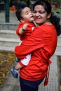 Loving mom carrying of her baby at society park. Bright portrait of happy mum holding child in her hands. Mother hugging her Royalty Free Stock Photo