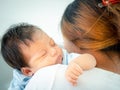 Loving mom carrying her sleeping newborn baby on her shoulder at home.Portrait of mum holding sleeping infant child on hands. Royalty Free Stock Photo