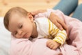 Loving mom carying of her baby daughter at home, mother holding sleeping infant child on hands, above view Royalty Free Stock Photo