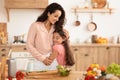 Loving mom embracing daughter while cooking together in modern kitchen Royalty Free Stock Photo