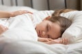 Mom hands touching sleeping kid daughter waking up little child