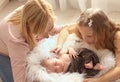 Loving mom and older sister hold the handle of a newborn boy and kiss, cute tiny baby. Portrait a Mom and her baby Royalty Free Stock Photo