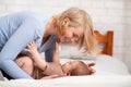 Loving mother caressing her baby boy on bed Royalty Free Stock Photo