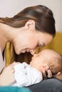 Loving Mother Cuddling Baby Son And Touching Noses