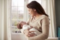 Loving Mother Cuddling Newborn Baby At Home Royalty Free Stock Photo