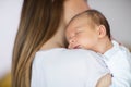 Loving Mother Cuddling Sleeping Newborn Baby Son Over Shoulder