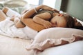 Loving mother with cute baby boy on chest lying in bed at home at daytime Royalty Free Stock Photo