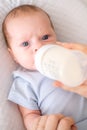 loving mother feeding her little boy child with milk baby bottle at home, portrait infant Baby eating, drinking powdered Royalty Free Stock Photo