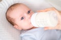 loving mother feeding her little boy child with milk baby bottle at home, portrait infant Baby eating, drinking powdered