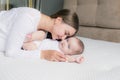 A loving mother and her little daughter. Young mother plays with her little beloved daughter on the couch