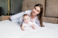 A loving mother and her little daughter. Young mother plays with her little beloved daughter on the couch