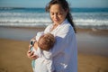 Loving mother holding her baby boy, rocking and kissing him while he& x27;s falling asleep in her arms Royalty Free Stock Photo