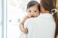 Loving mother holding and kisses the baby daughter,  A young mother  hugs and kisses her newborn daughter in the home Royalty Free Stock Photo