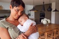 Loving Mother Holding Sleeping 3 Month Old Baby Daughter In Kitchen At Home Royalty Free Stock Photo