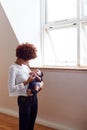 Loving Mother Holding Sleeping Newborn Baby By Window At Home In Loft Apartment Royalty Free Stock Photo