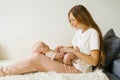 Loving mother holds her newborn baby in her arms at home, sitting on the couch Royalty Free Stock Photo
