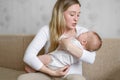 A loving mother holds, rocking, soothes her crying baby. A mother looks at her child with love and tenderness. Care Royalty Free Stock Photo