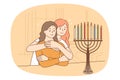 Jewish mom and daughter light menorah candle
