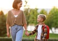 Loving mother and little son schoolboy with backpak holding hands while going to school together Royalty Free Stock Photo