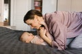 Loving mother looks at her baby lying on the bed Royalty Free Stock Photo