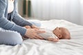 Loving Mother Making Belly Massage To Newborn Baby On Bed At Home Royalty Free Stock Photo