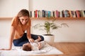 Loving Mother With Newborn Baby Lying On Bed At Home In Loft Apartment Royalty Free Stock Photo