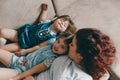 loving mom plays with her daughters lying on the couch