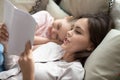 Loving mother reading book to sleepy cute little daughter Royalty Free Stock Photo