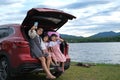 Loving mother taking a selfie with her children on a smartphone sitting together in the back of a car by a lake. Happy family, Royalty Free Stock Photo