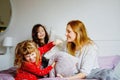 Loving mother and two little sisters girls making pillow fight together. Happy family, woman and cute daughters, toddler Royalty Free Stock Photo