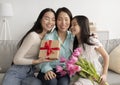 Loving multi generation Asian family with tulips and gift box hugging with closed eyes, celebrating Mother& x27;s Day at Royalty Free Stock Photo