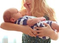 Loving older sister blonde sweetheart touching and gentle holds her newborn brother in her arms, cute tiny baby. Royalty Free Stock Photo