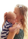 Loving older sister blonde sweetheart touching and gentle holds her newborn brother in her arms, cute tiny baby. Royalty Free Stock Photo