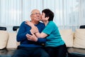 Loving older wife kissing smiling husband on cheek, expressing love and care, aged senior couple enjoying tender moment