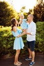 Loving overjoyed parents hold their adorable daughter