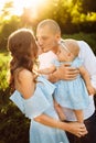 Loving overjoyed parents hold their adorable daughter