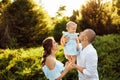 Loving overjoyed parents hold their adorable daughter