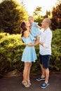 Loving overjoyed parents hold their adorable daughter