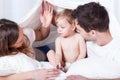 Loving parents with sad baby in bed Royalty Free Stock Photo