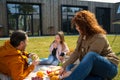 Loving parents talking with daughter during picnic outdoors