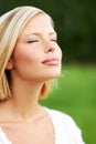 Loving the peace in nature. Lovely young woman savoring the breeze outdoors.