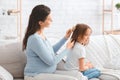 Loving pregnant woman combing her little daughter hair Royalty Free Stock Photo