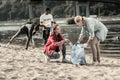 Loving responsible mother volunteering on the beach with her three children