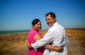 Loving Retired Couple Hugging Standing By Shore On Beach Vacation Royalty Free Stock Photo