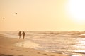 Loving Retired Senior Couple On Vacation Walking Along Beach Shoreline Holding Hands At Sunrise Royalty Free Stock Photo