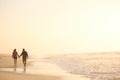 Loving Retired Senior Couple On Vacation Walking Along Beach Shoreline Holding Hands At Sunrise Royalty Free Stock Photo