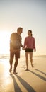 Loving Retired Senior Couple On Vacation Walking Along Beach Shoreline Holding Hands At Sunrise Royalty Free Stock Photo
