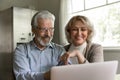 Loving retired spouses watch comedy movie on laptop screen Royalty Free Stock Photo