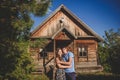 Loving romantic couple in the village, near a wooden house. Man embraces a young woman. Concept: love, romance, summer.